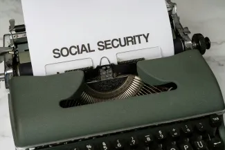 a close up of a typewriter with a paper that says social security by Markus Winkler courtesy of Unsplash.