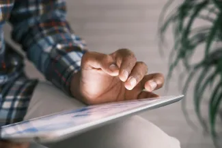 person in blue white and red plaid long sleeve shirt reading book by Towfiqu barbhuiya courtesy of Unsplash.
