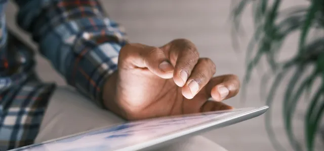 person in blue white and red plaid long sleeve shirt reading book by Towfiqu barbhuiya courtesy of Unsplash.
