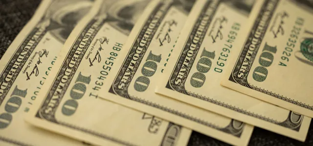 a pile of twenty dollar bills laying on top of each other by engin akyurt courtesy of Unsplash.